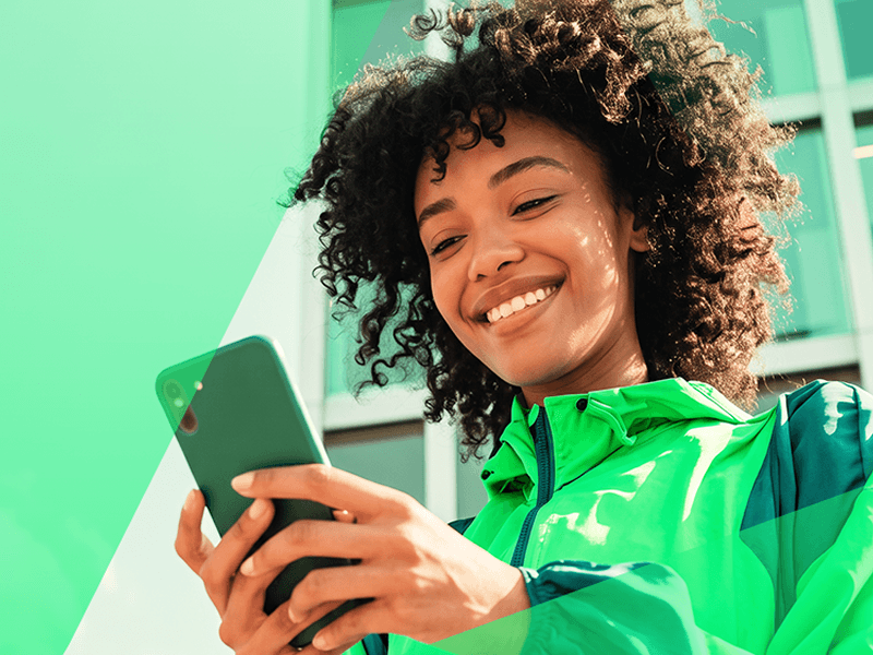 Parceira Anthor sorrindo ao usar o aplicativo no celular
